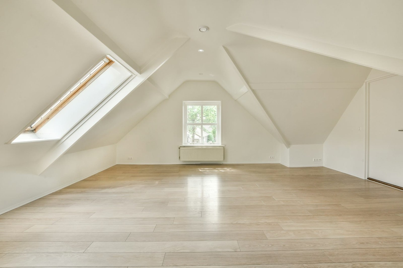 a loft conversion with a wood floor and white walls